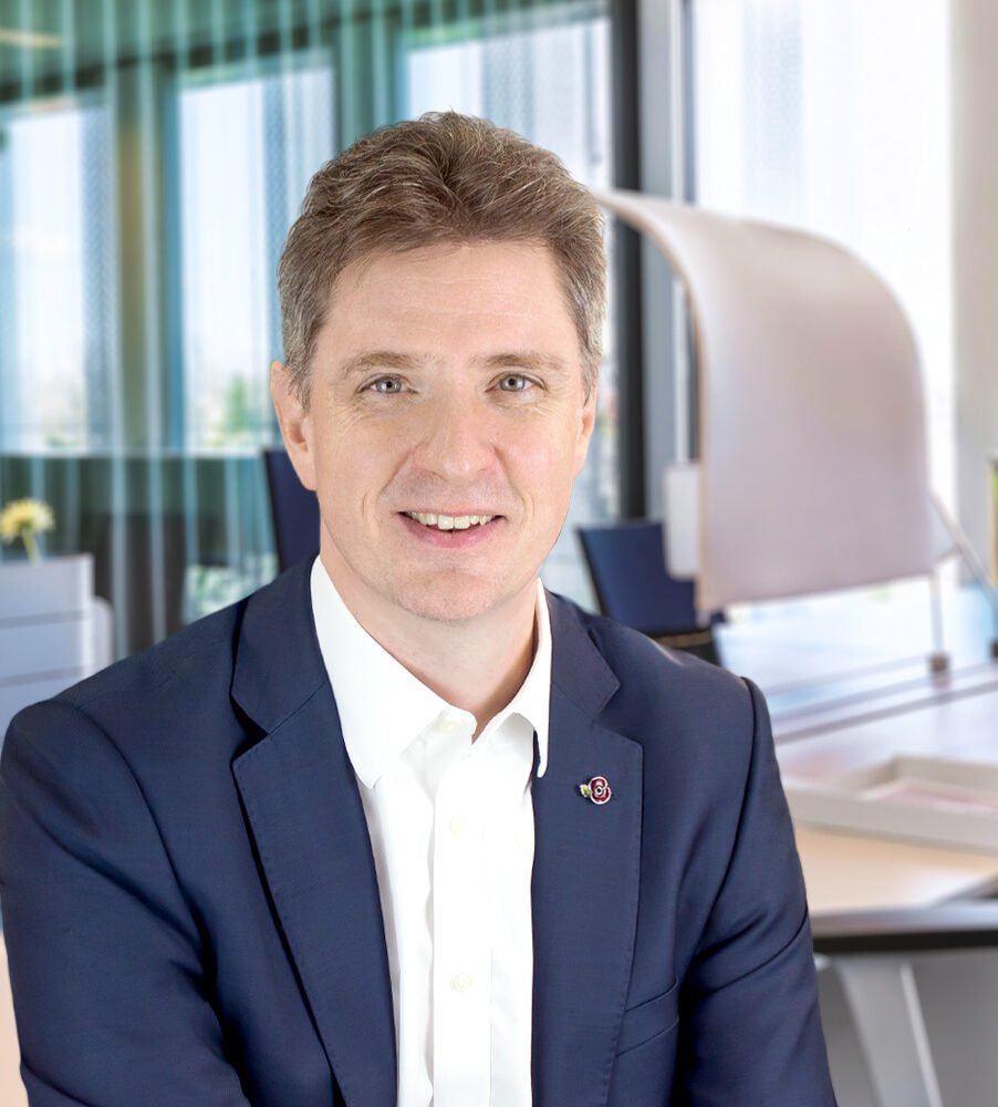 man wearing white shit blue suit with office background